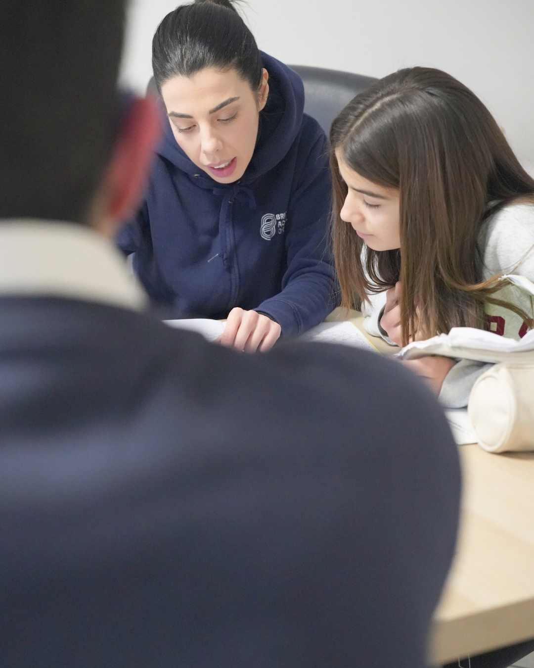 Ragazza che legge aiutata dalla maestra